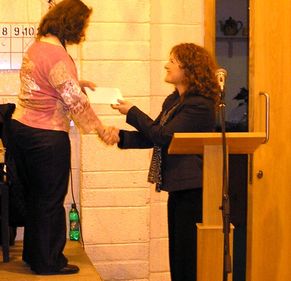 Ruth receives a presentation from Deidre Kerr, the chair of the Parish Pastora Council Ruth receives a presentation from Deidre Kerr, the chair of the Parish Pastora Council